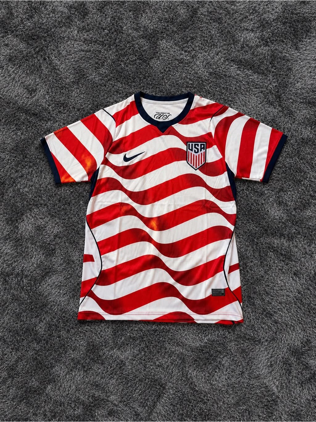 USA red and white striped soccer jersey laid flat
