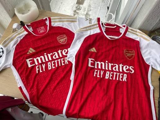 Two red football jerseys laid side by side for fit comparison