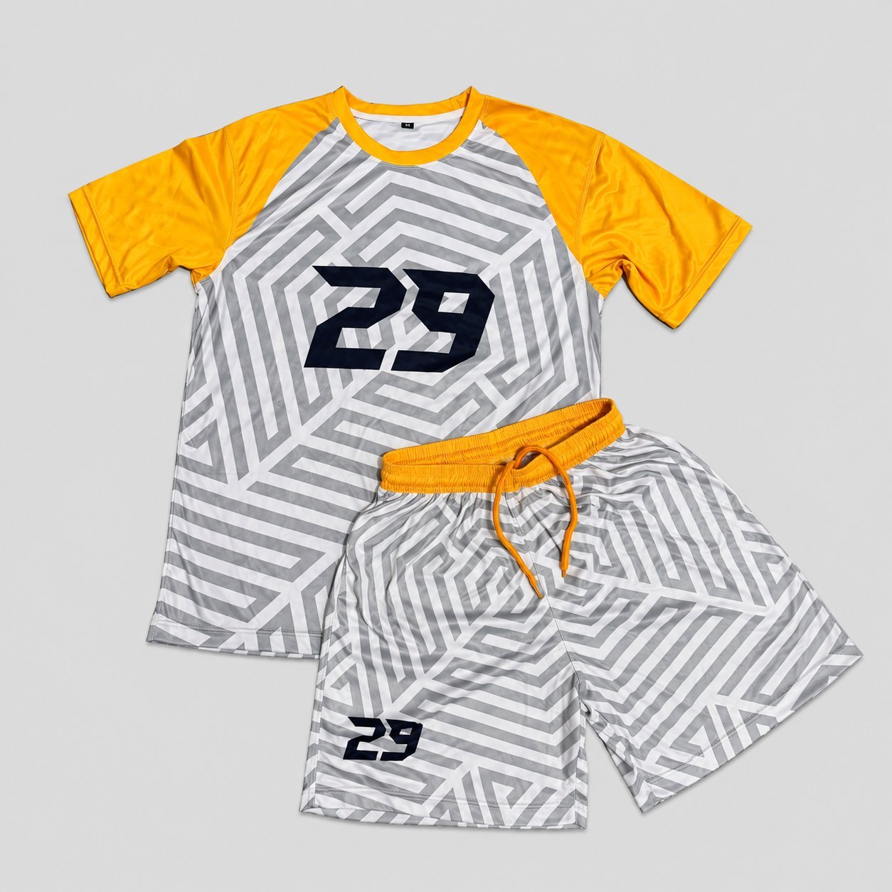 Custom #29 geometric gray and yellow raglan soccer jersey with matching shorts showing finished iron-on number customization